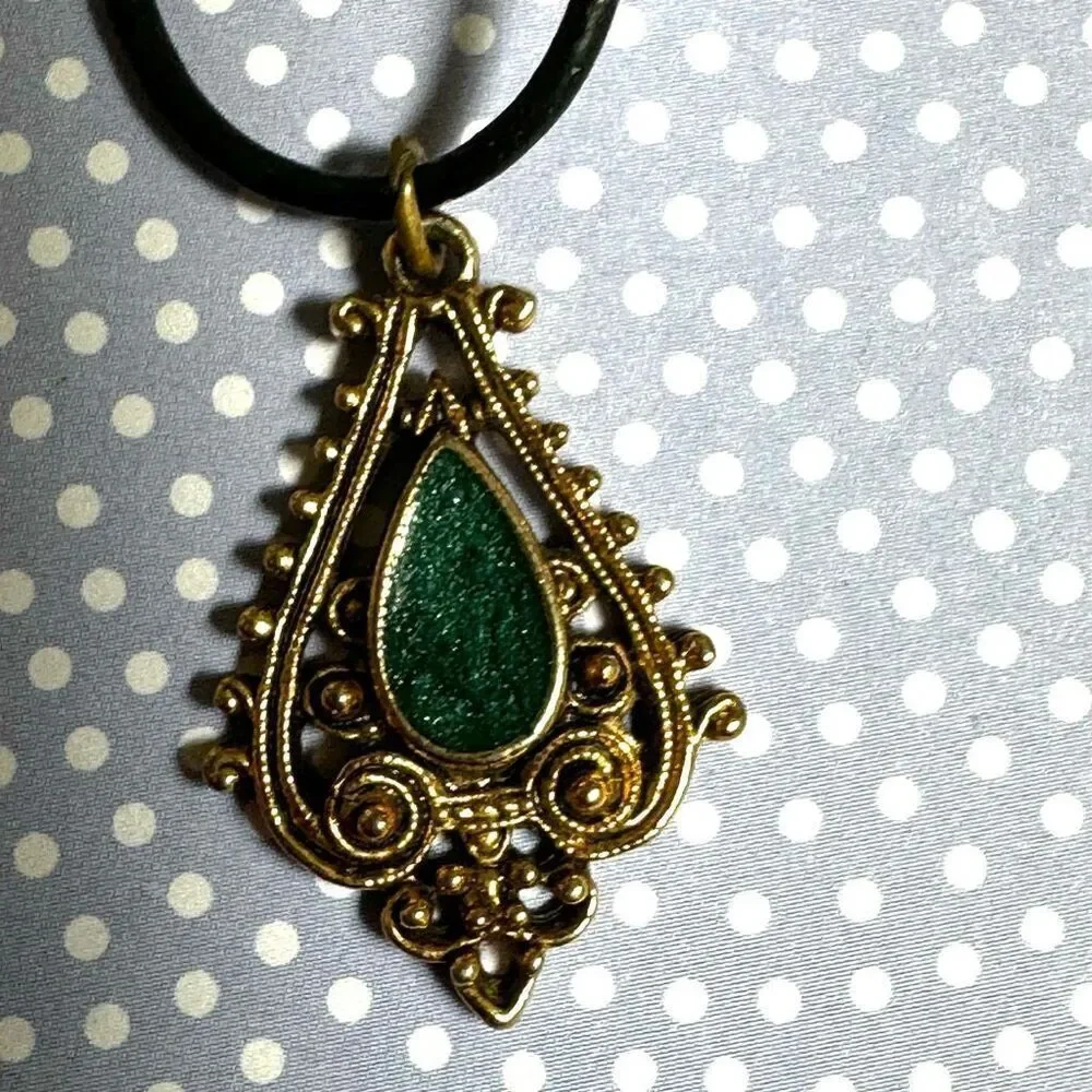 Green and gold tone pendant necklace on black cord